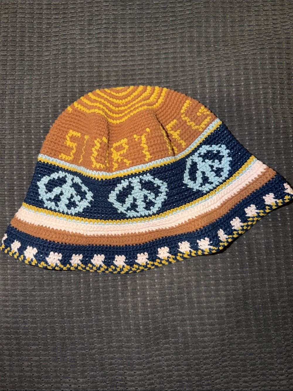 Story Mfg. Crochet Peace Sign Bucket Hat in Mustard, Navy & Tan